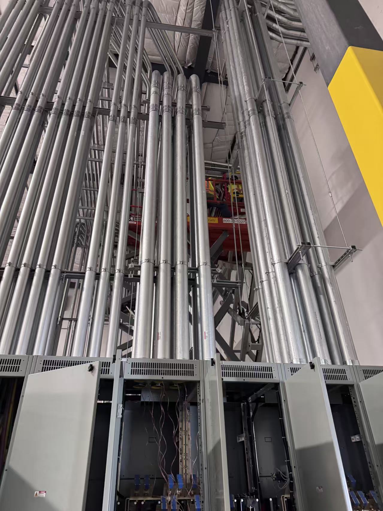 Industrial conduit routing above electrical panels